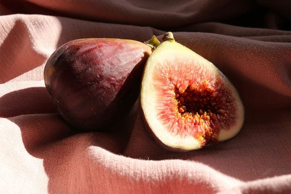 Zwei Feigen liegen nebeneinander, eine davon aufgeschnitten – Sinnbild für Sexualberatung, Körperlichkeit und Intimität in der Paartherapie.
